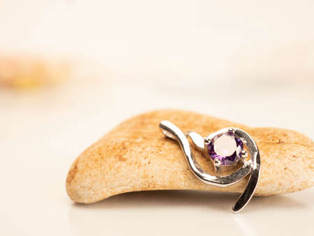 Close up shot of white gold pendat with shiny purple stoneの写真素材