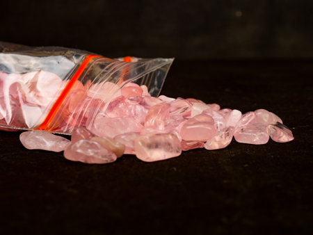 Rough pink colored diamond on black background