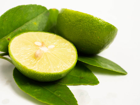 Picture of green citrus with leafs on a white isolated backgroundの写真素材