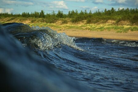 view to the beach of the Baltic sea on warm sunny summer day from inside a barrelling wave