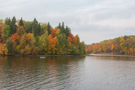 View to the boat with fishermen fishing in the Perse river in Koknese.  Colorful red and yellow...