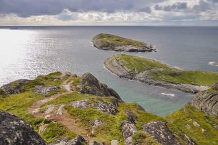 View from Lovund hills to the rocky coastline and the small green rocky islands of Lovund...