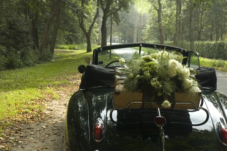 A classic wedding car and a bouquet of flowersの写真素材