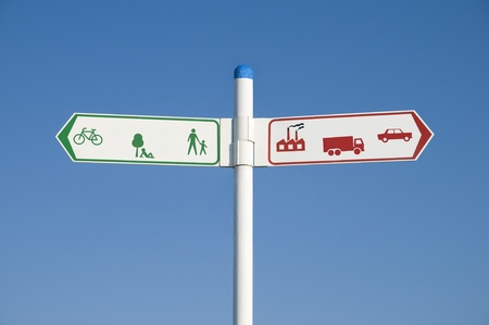 Environmental signpost or road sign showing green arrow to the left and red arrow to the right....