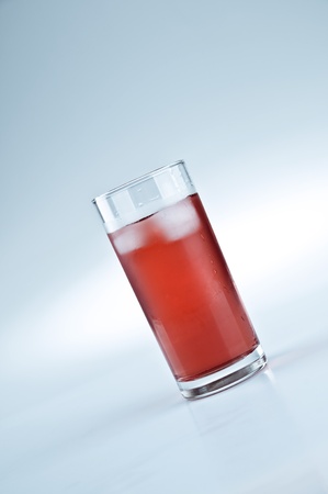 Glass of red lemonade and ice cubesの写真素材