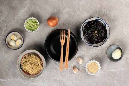 Empty Ttukbaegi Flat Lay Concept Ingredients of Jajangmyeon or Jjajangmyeon, Korean Noodle with Black Bean Sauce. On Grey Cement Wooden Backgroundの写真素材
