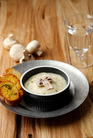 Mushroom Cream  Soup with Crispy Garlic Bread on Wooden Tableの写真素材