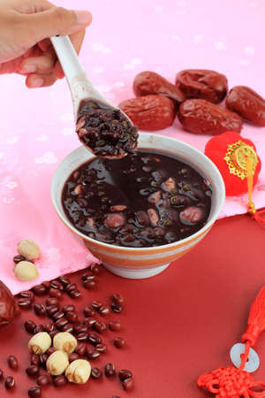 Chinese Food. The delicious Eight Treasures Porridge on the Table, Hand Take Spoon from the Laba...