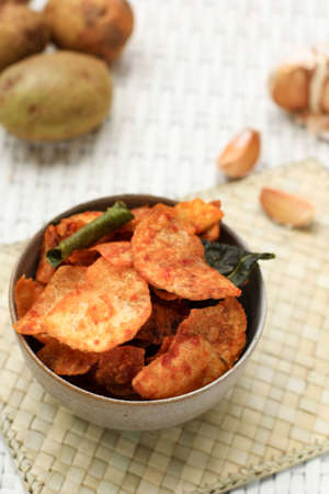 Homemade Kering Kentang Balado or Spicy Sweet Crispy Potato with Caramelized Spice. Using Lime Leaf for Aromatic Spice. Served on Grey Bowl, White Background. Selected Focusの写真素材