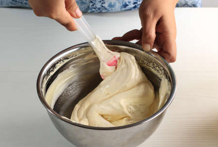 Folding Technique (Aduk Balik) Cream Batter on Stainless Bowl. Female Hand Chef Process Step by Step...