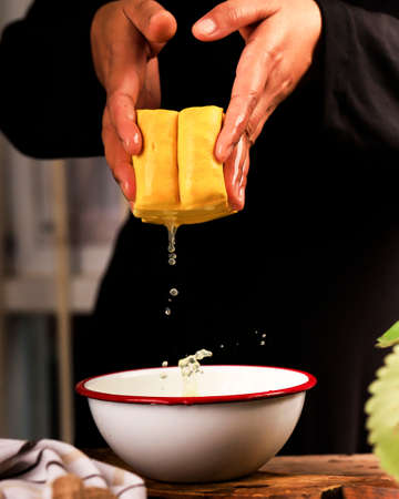 Asian Woman Preparing Raw Yellow Tofu, Clean the Tofu with Water in Rustic Kitchen