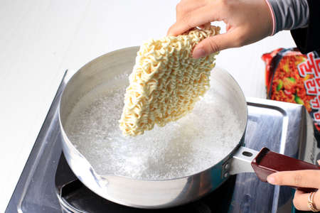 Boiling Korean Instant Noodle (Spicy Ramyun) on Sauce Pan, Add Noodle to the Pan, Home Cooking Activityの写真素材