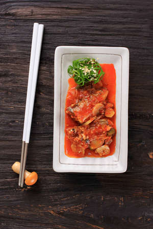Braised Mackerel or Godeungeo Jorim, One Various of Korean Side Dish Banchan for Lunch or Dinner, Served on Wooden Table, White Plateの写真素材