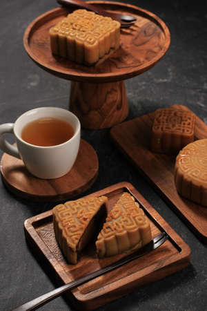 Mooncake on Black Background with Tea. Concept Moon Cake on Mid Autumn Festival or Chinese New year...