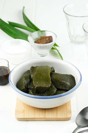 Green Grass Jelly or Cincau Hijau on a Bowl, Usually Served with Coconut Milk and Palm Sugar Sauce