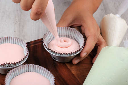 Female Hand Pour Pink Cupcake Batter to the Mold with Beatiful Papercup, Baking Process Step by Step...