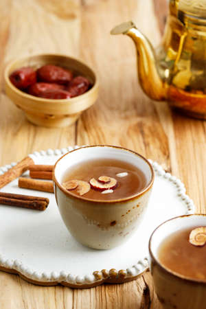 Sujeonggwa, Korean Traditional Cinnamon Punch. Dark Reddish Brown in Color, it is Made from Cinnamon Stick, Gotgam, and Ginger and is Garnished with Pine Nuts and Red Dates Jujube.の写真素材