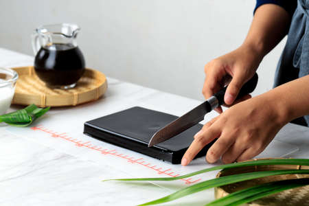 Female Homemaker Cut Cincau Hitam or Black Grass Jelly Pudding into Pieces, Healthy Foodの写真素材