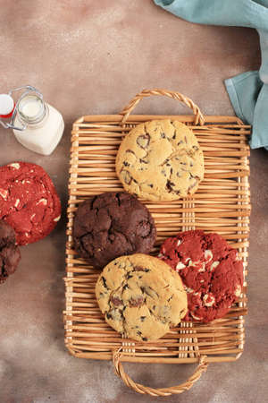 Various Soft American Cookies, Vanilla, Red Velvet and Dark Chocolate Chips on Rustic Table. Top...