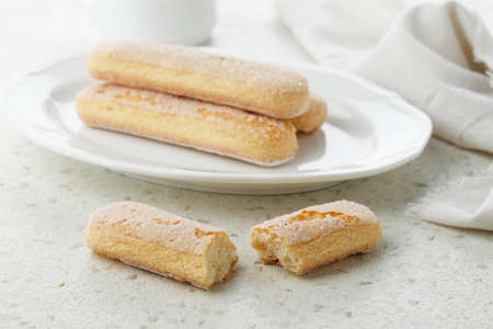 Italian Cookie Savoiardi. Ladyfinger Sweet Biscuits. Sponge Cookies Tiramisu on Cream Table. Selected Focusの写真素材