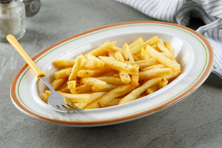 Portion of French Fries on WHite Plate, Close Up . Concept Fast Food