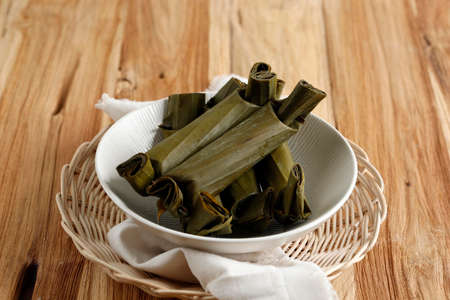 Lontong is an Indonesian dish. Rice is rolled inside a banana leaf and boiled, then cut into small cakes as a staple food replacement of steamed rice.の写真素材
