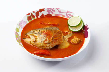 Delicious King Fish Head Sweet and Sour Curry Cooked with Tomato, Lime, Chilli, and other Traditional Spices. Popular as Gulai Kepala Ikanの写真素材