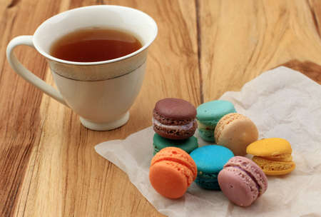 Baby Macaroon on Wooden Table, Served with a Cup of Tea. Selected Focus