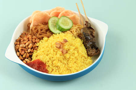 A Plate of Nasi Kuning or Yellow Rice, Favorite Indonesian Menu for Breakfast. Popular Street Food, Yellow Color came from Turmericの写真素材