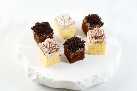 Small Square Sponge Cakes Cake Potong with Chocolate Shredded Dark Cooking Chocolate and Cream over White Background.の写真素材