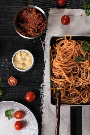 Top View Spaghetti Bolognaise Served on Black Pan with Grated ParmesanCheese. Selected Focus with...