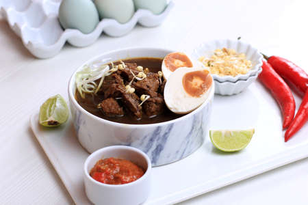 Rawon, Indonesian Beef Black Soup Dish.  Black Color Made from Keluak Nut as the Main Seasoning,...