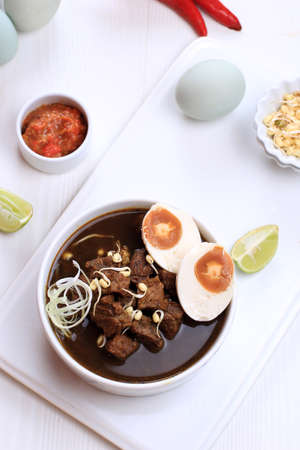 Top View Rawon, Indonesian Beef Black Soup Dish.  Black Color Made from Keluak Nut as the Main...