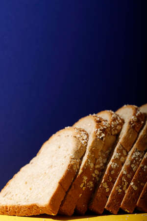 White Bread with Whole Grain Cereal Topping on Blue Background, Copy Space for Textの写真素材