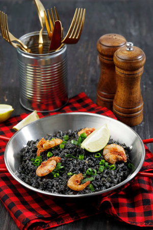 Black Paella with Prawn and Lemon, Seafood Spanish Food on Wooden Tableの写真素材