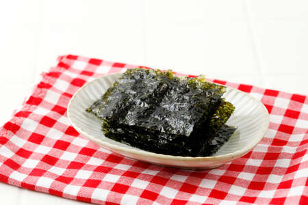 Toasted Nori Laver Seasoned Seaweed and Sesame Snacks, Popular in Japan and Korea, Served on Ceramic...
