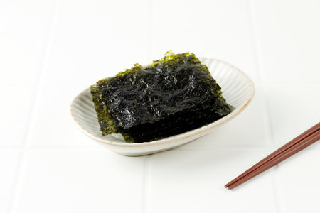 Crispy Salted Nori Laver Sheet on White Plate, Popular in Japan and Korea for Sushi and Kimbap. Copy Space for Textの素材 [FY310193247998]