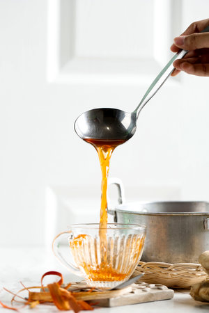 Pouring Wedang Uwuh to the Tea Cup, Red Herbal Tea made from Various Leaf, Wood, and Herbs, Popular in Indonesia. Copy Space for Textの写真素材