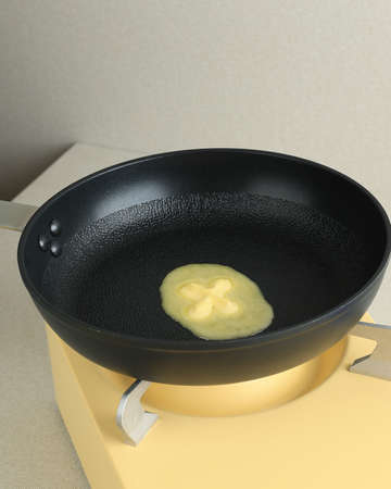 Melted Butter on Black Skillet Pan Above Portable Stove