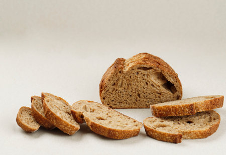 Bread, Traditional Sourdough Bread Cut into Slices on a Cream Light Background. Copy Space for Textの写真素材