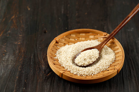Sesame Seed on Bamboo Plate with Wooden Spoon, Copy Space for Textの写真素材