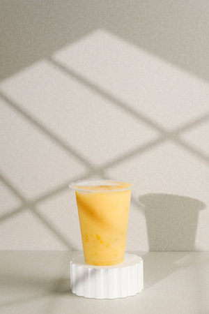 Mango Juice Mangga Kweni Kaweni on Plastic CUp above Wooden Podium. Concept Drink to Go