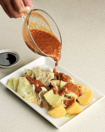 Pour Spicy Peanut Sauce Dressing to Baso Tahu Bandung. Baso Tahu is Steamed DUpling with Fish and Tapioca Batter.の写真素材