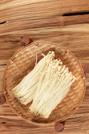 Fresh Golden Needle Mushroom or Enoki, Enokitake Flammulina velutipes on Wooden Table, Top View