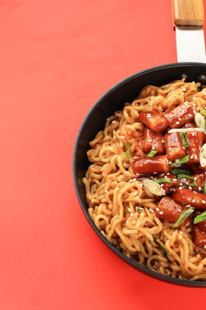 Rabokki, Korean Popular Street Food Style. Tteokbokki Topokki with Instant Ramen on Pan, above Red Tableの写真素材