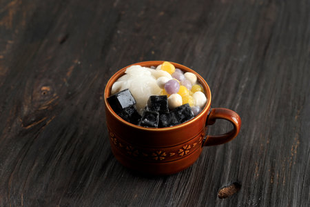 Sweet Taiwanese Dessert with Toppings. Grass Jelly and Taro Balls on Wooden Table. Known as