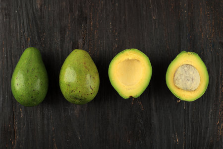 Fresh Ripe Avocado on Black Wooden Table, Top View. Copy Space for Textの写真素材