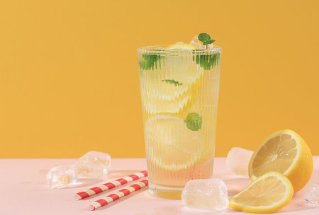 Fresh Lemonade with Cylinder Ice with Mint Leaf, Fresh Summer Drink on Yellow and Pink Backgroundの写真素材