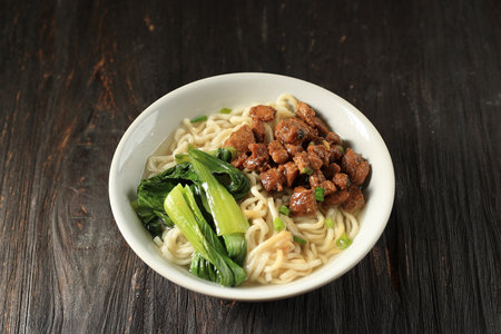 Mie Ayam, Indonesian Popular Street Food with Noodle, Chicken, and Green Vegetables with Delicious...