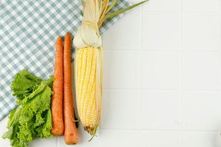 Corn, Carrot, and Lettuce Top View on White Background. Copy Space for Textの写真素材